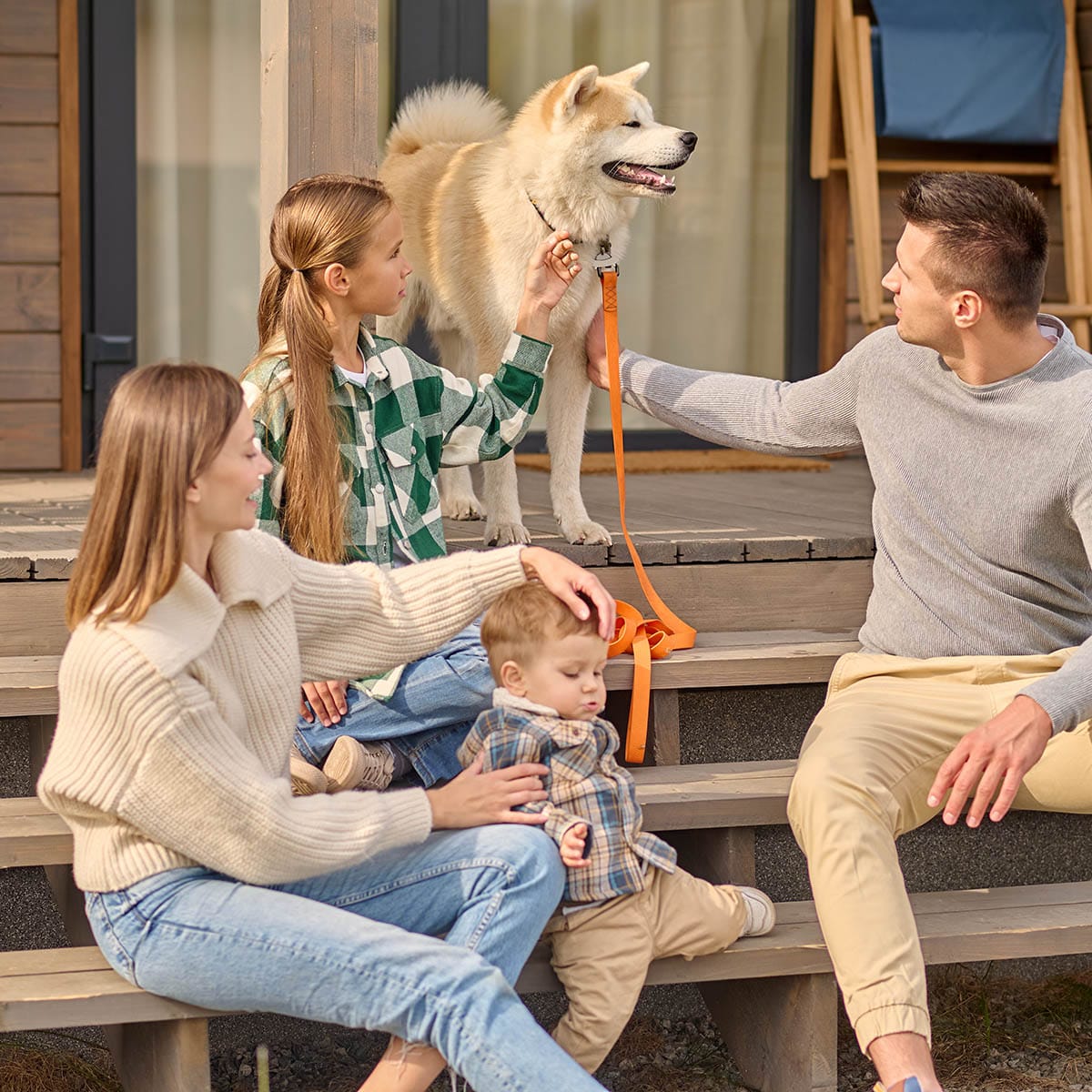 Girl and man touching dog and woman with child